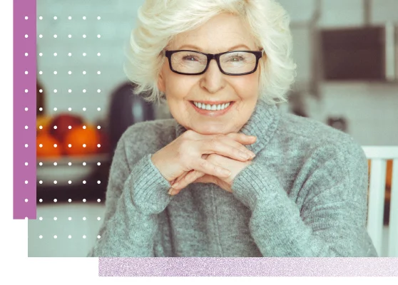 Eine Frau mit Brille mittleren Alters lächelt und schaut in die Kamera.