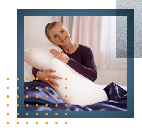 Eine junge Frau liegt seitlich schlafend im Bett, die Hände unterm Kopf