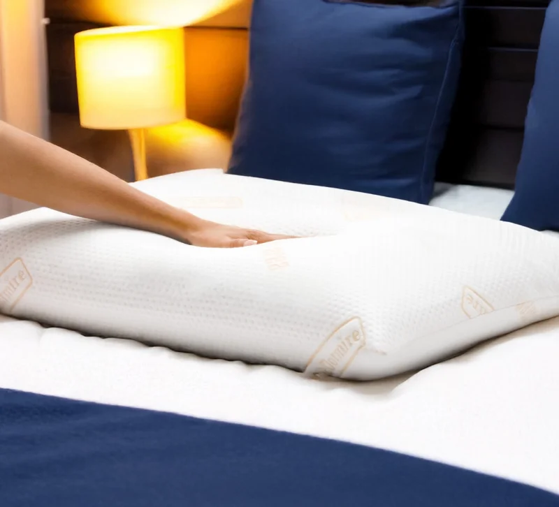 Hand drückt ein orthopädisches Kopfkissen ein, welches sich perfekt an die Handform anschmiegt